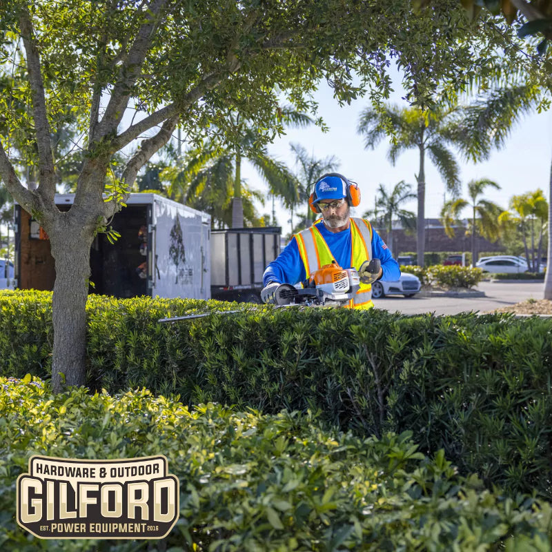 The STIHL HS 87 T hedge trimmer in action on a commercial landscaping job, demonstrating its efficiency and clean cutting capabilities.