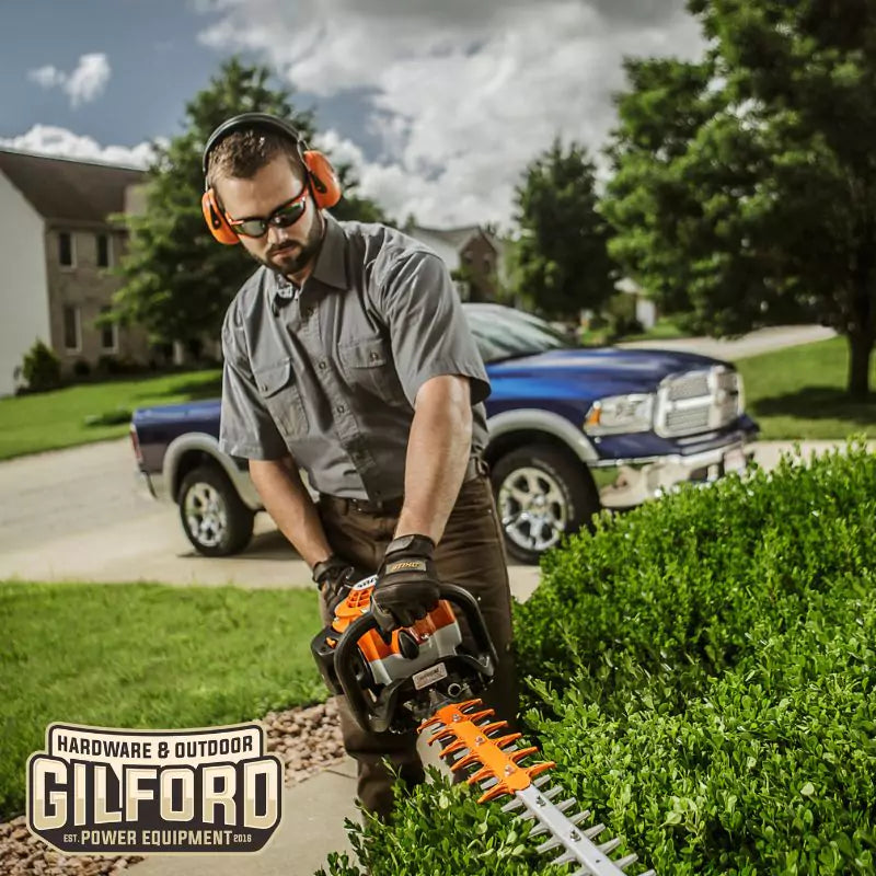 Landscaping professional trimming hedges with the STIHL HS 82 R, emphasizing its heavy-duty gas-powered performance.